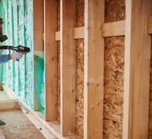 Interior wall framing showing wooden studs with spray foam insulation