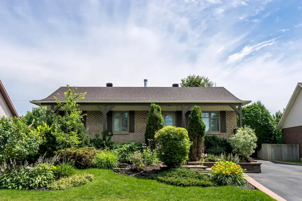 Brick veneer bungalow exterior with low-pitched roof in Ottawa suburb